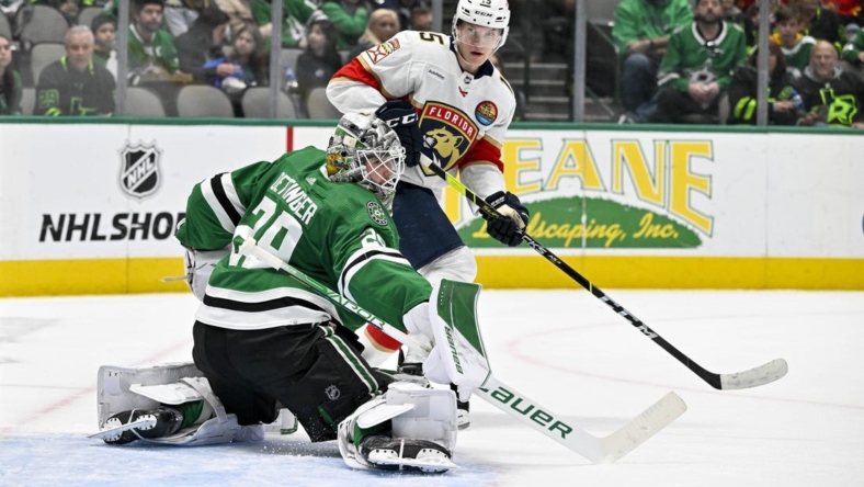 Jan 8, 2023; Dallas, Texas, USA; Dallas Stars goaltender Jake Oettinger (29) turns away a shot as Florida Panthers center Anton Lundell (15) looks for the puck rebound during the first period at the American Airlines Center. Mandatory Credit: Jerome Miron-USA TODAY Sports