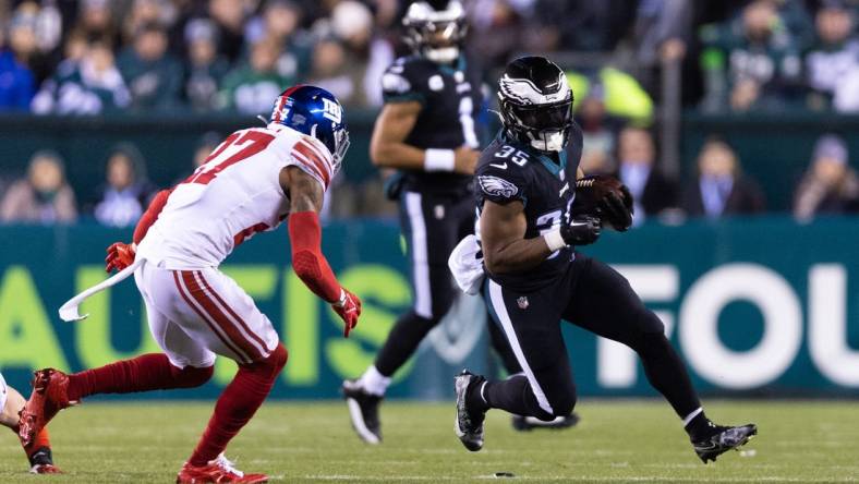 Jan 8, 2023; Philadelphia, Pennsylvania, USA; Philadelphia Eagles running back Boston Scott (35) runs with the ball against New York Giants cornerback Jason Pinnock (27) during the second quarter at Lincoln Financial Field. Mandatory Credit: Bill Streicher-USA TODAY Sports