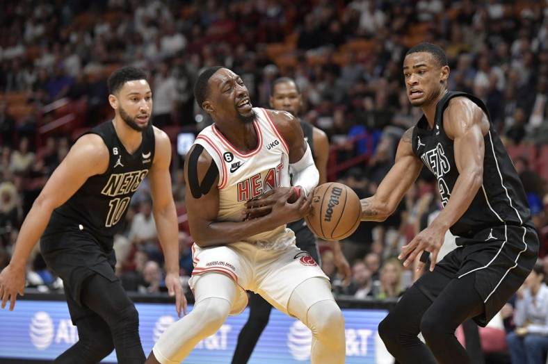 Jan 8, 2023; Miami, Florida, USA;  Miami Heat center Bam Adebayo (13) loses the ball in front of Brooklyn Nets center Nic Claxton (13) during the first quarter of their game at FTX Arena. Mandatory Credit: Michael Laughlin-USA TODAY Sports
