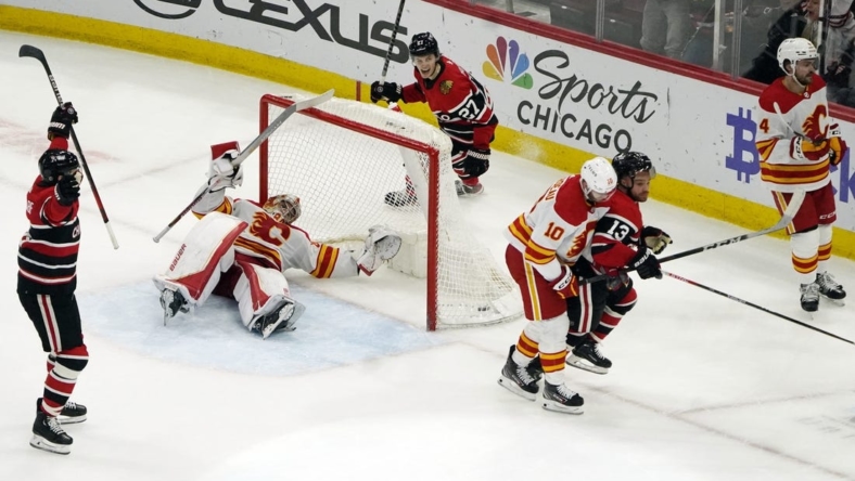 Jan 8, 2023; Chicago, Illinois, USA; Chicago Blackhawks center Max Domi (13) scores the game winning goal against the Calgary Flames during a overtime period at United Center. Mandatory Credit: David Banks-USA TODAY Sports