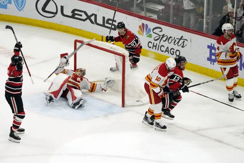 Jan 8, 2023; Chicago, Illinois, USA; Chicago Blackhawks center Max Domi (13) scores the game winning goal against the Calgary Flames during a overtime period at United Center. Mandatory Credit: David Banks-USA TODAY Sports