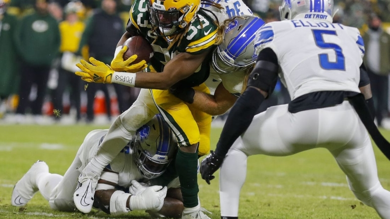 Jan 8, 2023; Green Bay, Wisconsin, USA;  Green Bay Packers running back Aaron Jones (33) is tackled by Detroit Lions linebacker Alex Anzalone (34) and defensive end Isaiah Buggs (96) at Lambeau Field. Mandatory Credit: Tork Mason/USA Today NETWORK-Wisconsin