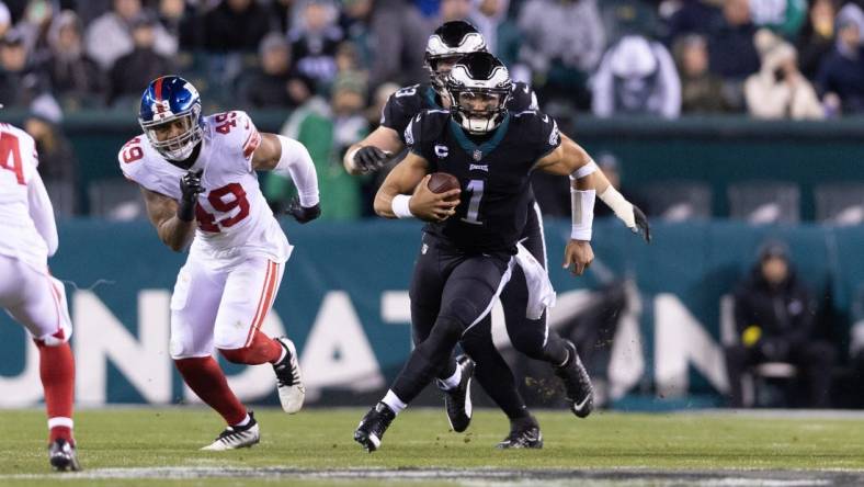 Jan 8, 2023; Philadelphia, Pennsylvania, USA; Philadelphia Eagles quarterback Jalen Hurts (1) runs with the ball in front of New York Giants linebacker Tomon Fox (49) during the third quarter at Lincoln Financial Field. Mandatory Credit: Bill Streicher-USA TODAY Sports