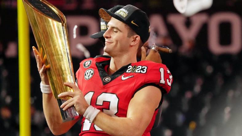 Jan 9, 2023; Inglewood, CA, USA; Georgia Bulldogs quarterback Stetson Bennett (13) holds the trophy after winning the CFP national championship game against the TCU Horned Frogs at SoFi Stadium. Mandatory Credit: Kirby Lee-USA TODAY Sports