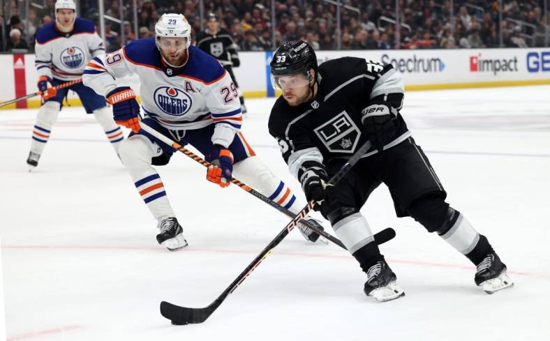 Jan 9, 2023; Los Angeles, California, USA; Los Angeles Kings right wing Viktor Arvidsson (33) controls the puck in front of Edmonton Oilers center Leon Draisaitl (29) during the second period against the Edmonton Oilers at Crypto.com Arena. Mandatory Credit: Jason Parkhurst-USA TODAY Sports