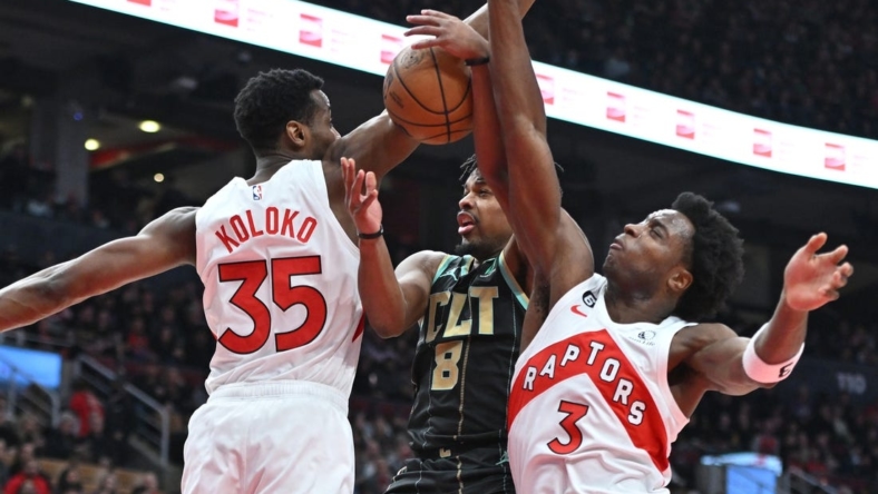 Jan 10, 2023; Toronto, Ontario, CAN;  Charlotte Hornets guard Dennis Smith Jr. (8) has his shot attempt blocked by Toronto Raptors center Christian Koloko (35) and forward OG Anunoby (3) in the first half at Scotiabank Arena. Mandatory Credit: Dan Hamilton-USA TODAY Sports