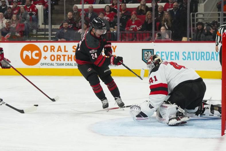 Jan 10, 2023; Raleigh, North Carolina, USA;  New Jersey Devils goaltender Vitek Vanecek (41) pokes the puck away from Carolina Hurricanes center Seth Jarvis (24) during the first period at PNC Arena. Mandatory Credit: James Guillory-USA TODAY Sports