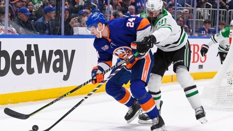 Jan 10, 2023; Elmont, New York, USA;  Dallas Stars center Tyler Seguin (91) and New York Islanders defenseman Scott Mayfield (24) battle for the puck during the first period at UBS Arena. Mandatory Credit: Dennis Schneidler-USA TODAY Sports