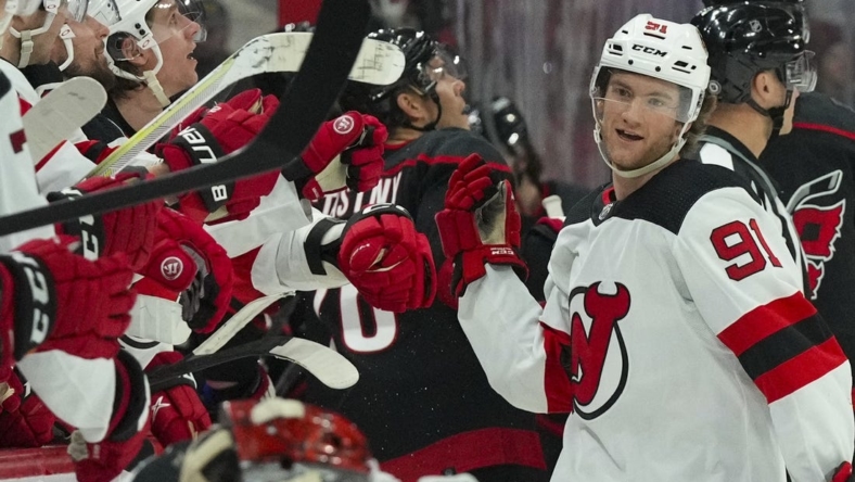Jan 10, 2023; Raleigh, North Carolina, USA;  New Jersey Devils center Dawson Mercer (91) is congratulated after a goal against the Carolina Hurricanes during the third period at PNC Arena. Mandatory Credit: James Guillory-USA TODAY Sports