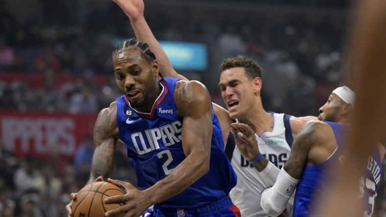 Jan 10, 2023; Los Angeles, California, USA;  Los Angeles Clippers forward Kawhi Leonard (2) reaches in front of Dallas Mavericks center Dwight Powell (7) for a rebound in the first half at Crypto.com Arena. Mandatory Credit: Jayne Kamin-Oncea-USA TODAY Sports