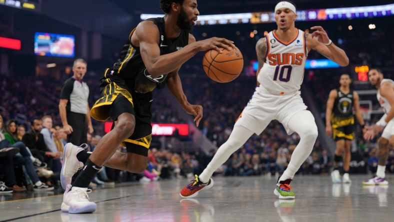 Jan 10, 2023; San Francisco, California, USA; Golden State Warriors forward Andrew Wiggins (22) dribbles past Phoenix Suns guard Damion Lee (10) in the second quarter at the Chase Center. Mandatory Credit: Cary Edmondson-USA TODAY Sports