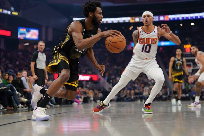Jan 10, 2023; San Francisco, California, USA; Golden State Warriors forward Andrew Wiggins (22) dribbles past Phoenix Suns guard Damion Lee (10) in the second quarter at the Chase Center. Mandatory Credit: Cary Edmondson-USA TODAY Sports