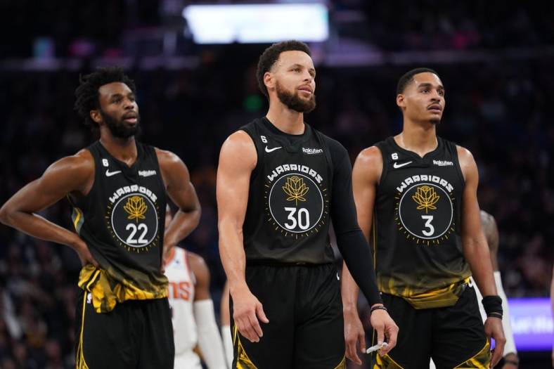 Jan 10, 2023; San Francisco, California, USA; Golden State Warriors guard Stephen Curry (30) stands next to forward Andrew Wiggins (22) and guard Jordan Poole (3) after a foul was called against the Warriors during action against the Phoenix Suns in the fourth quarter at the Chase Center. Mandatory Credit: Cary Edmondson-USA TODAY Sports