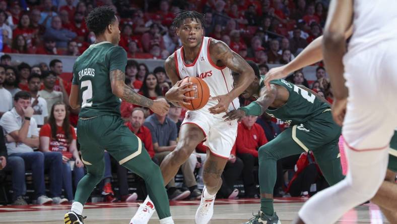 Jan 11, 2023; Houston, Texas, USA; Houston Cougars guard Marcus Sasser (0) drives with the ball as South Florida Bulls guard Tyler Harris (2) defends during the first half at Fertitta Center. Mandatory Credit: Troy Taormina-USA TODAY Sports