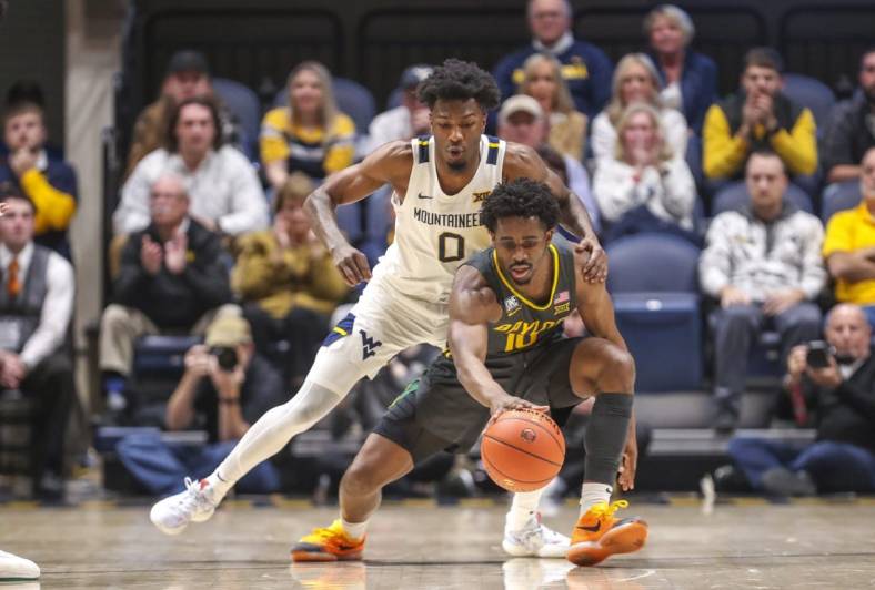 Jan 11, 2023; Morgantown, West Virginia, USA; West Virginia Mountaineers guard Kedrian Johnson (0) defends against Baylor Bears guard Adam Flagler (10) during the second half at WVU Coliseum. Mandatory Credit: Ben Queen-USA TODAY Sports