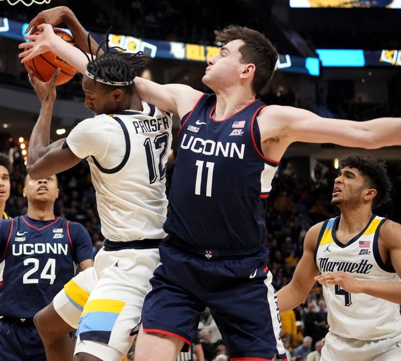 Jan 11, 2023; Milwaukee, Wisconsin, USA; Marquette forward Olivier-Maxence Prosper (12) and Connecticut forward Alex Karaban (11) battle for a rebound during the second half at Fiserv Forum. Mandatory Credit: Mark Hoffman-USA TODAY Sports