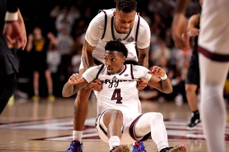 Jan 11, 2023; College Station, Texas, USA; Texas A&M Aggies guard Wade Taylor IV (4) is helped up by guard Dexter Dennis (0) after being fouled against the Missouri Tigers during the second half at Reed Arena. Mandatory Credit: Erik Williams-USA TODAY Sports