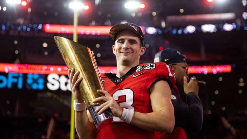 Jan 9, 2023; Inglewood, CA, USA; Georgia Bulldogs quarterback Stetson Bennett (13) celebrates with the championship trophy after defeating the TCU Horned Frogs during the CFP national championship game at SoFi Stadium. Mandatory Credit: Mark J. Rebilas-USA TODAY Sports