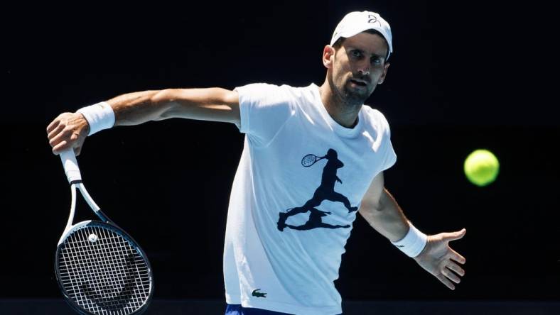 Jan 12, 2023; Melbourne, Victoria, Australia; Novak Djokovic of Serbia hits a backhand during a practice session on Rod Laver Arena with his coach Goran Ivanisevic at Melbourne Park. Mandatory Credit: Mike Frey-USA TODAY Sports