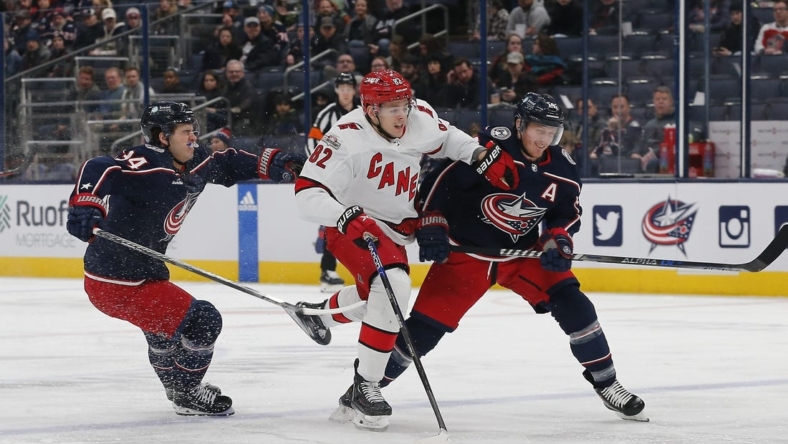 Jan 12, 2023; Columbus, Ohio, USA; Carolina Hurricanes center Jesperi Kotkaniemi (82) avoids then check from Columbus Blue Jackets center Gustav Nyquist (14) during the first period at Nationwide Arena. Mandatory Credit: Russell LaBounty-USA TODAY Sports
