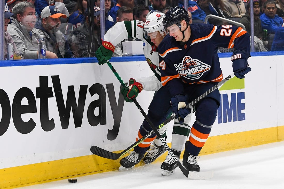 Jan 12, 2023; Elmont, New York, USA;  Minnesota Wild left wing Kirill Kaprizov (97) and New York Islanders defenseman Scott Mayfield (24) battle for the puck behind the net during the first period at UBS Arena. Mandatory Credit: Dennis Schneidler-USA TODAY Sports