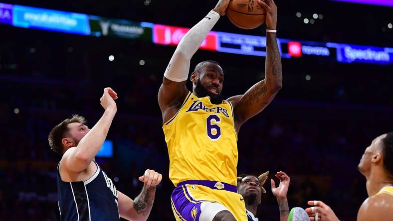 Jan 12, 2023; Los Angeles, California, USA; Los Angeles Lakers forward LeBron James (6) gets the rebound against Dallas Mavericks guard Luka Doncic (77) during the second half at Crypto.com Arena. Mandatory Credit: Gary A. Vasquez-USA TODAY Sports