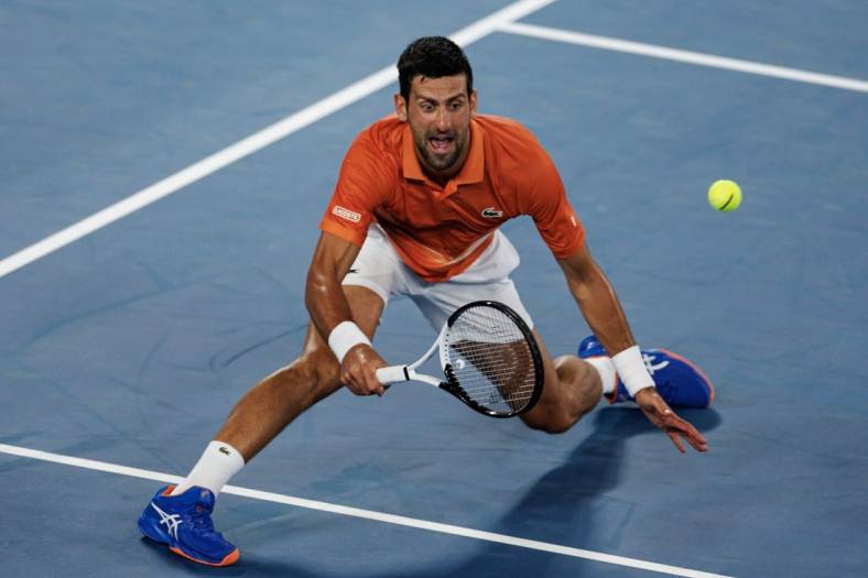 Jan 13, 2023; Melbourne, Victoria, Australia; Novak Djokovic of Serbia hits a shot during an exhibition practice match against Nick Kyrgios of Australia on Rod Laver Arena at Melbourne Park. Mandatory Credit: Mike Frey-USA TODAY Sports