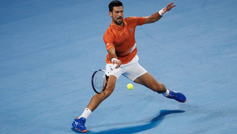 Jan 13, 2023; Melbourne, Victoria, Australia; Novak Djokovic of Serbia hits a shot during an exhibition practice match against Nick Kyrgios of Australia on Rod Laver Arena at Melbourne Park. Mandatory Credit: Mike Frey-USA TODAY Sports