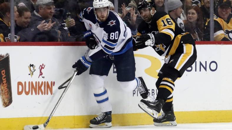 Jan 13, 2023; Pittsburgh, Pennsylvania, USA;  Winnipeg Jets left wing Pierre-Luc Dubois (80) moves the puck against Pittsburgh Penguins left wing Jason Zucker (16) during the first period at PPG Paints Arena. Mandatory Credit: Charles LeClaire-USA TODAY Sports