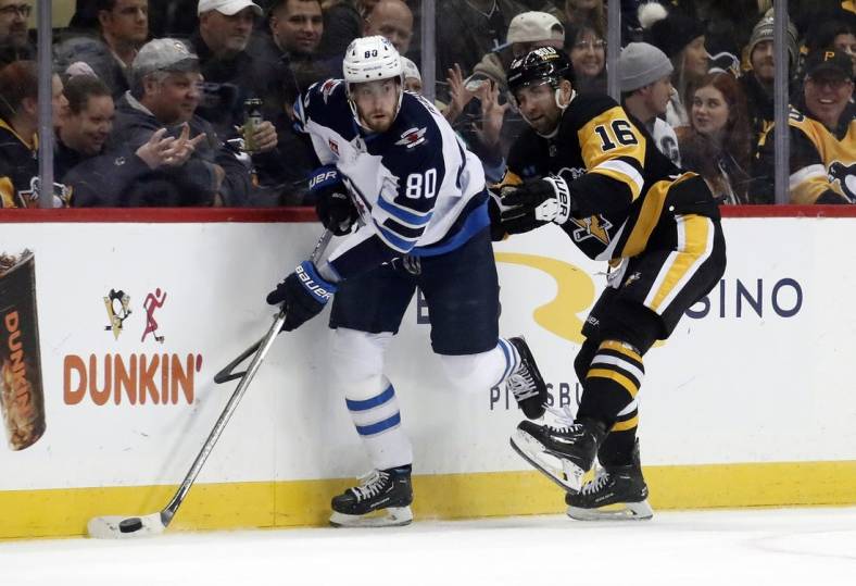 Jan 13, 2023; Pittsburgh, Pennsylvania, USA;  Winnipeg Jets left wing Pierre-Luc Dubois (80) moves the puck against Pittsburgh Penguins left wing Jason Zucker (16) during the first period at PPG Paints Arena. Mandatory Credit: Charles LeClaire-USA TODAY Sports