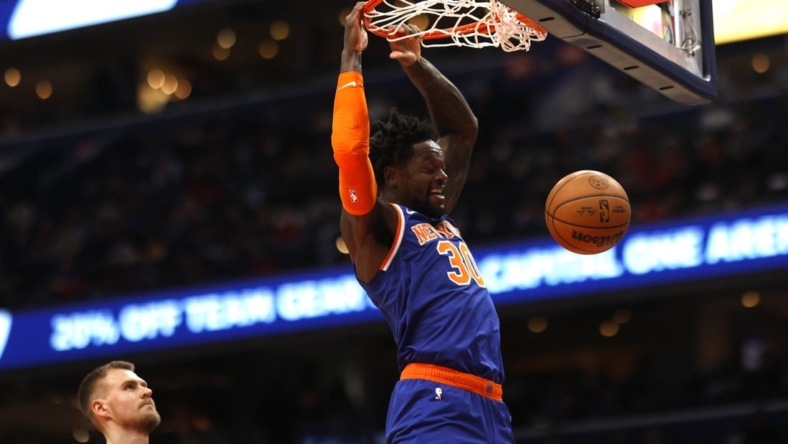 Jan 13, 2023; Washington, District of Columbia, USA; New York Knicks forward Julius Randle (30) dunks the ball as Washington Wizards center Kristaps Porzingis (6) looks on in the first quarter at Capital One Arena. Mandatory Credit: Geoff Burke-USA TODAY Sports