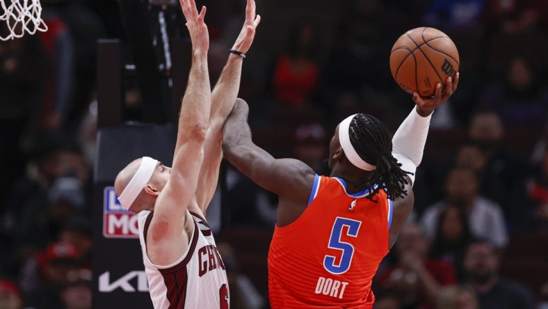 Jan 13, 2023; Chicago, Illinois, USA; Oklahoma City Thunder guard Luguentz Dort (5) goes to the basket against Chicago Bulls guard Alex Caruso (6) during the first half at United Center. Mandatory Credit: Kamil Krzaczynski-USA TODAY Sports