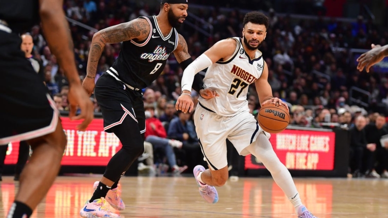 January 13, 2023; Los Angeles, California, USA; Denver Nuggets guard Jamal Murray (27) moves the ball against Los Angeles Clippers forward Marcus Morris Sr. (8) during the second half at Crypto.com Arena. Mandatory Credit: Gary A. Vasquez-USA TODAY Sports