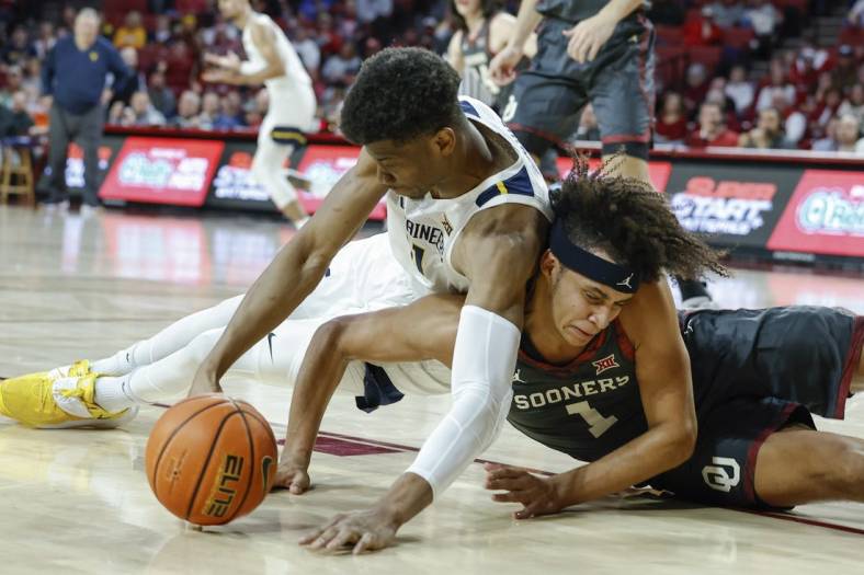 Jan 14, 2023; Norman, Oklahoma, USA; West Virginia Mountaineers forward Mohamed Wague (11) and Oklahoma Sooners forward Jalen Hill (1) fight for a loose ball during the first half at Lloyd Noble Center. Mandatory Credit: Alonzo Adams-USA TODAY Sports
