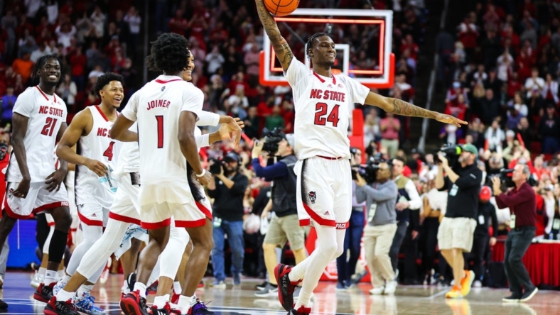 Jan 14, 2023; Raleigh, North Carolina, USA; North Carolina State Wolfpack forward Ernest Ross (24) and teammates celebrate the end of the overtime against Miami Hurricanes at PNC Arena. Mandatory Credit: Jaylynn Nash-USA TODAY Sports
