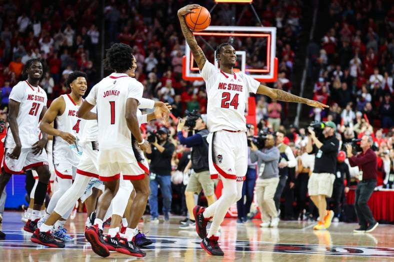Jan 14, 2023; Raleigh, North Carolina, USA; North Carolina State Wolfpack forward Ernest Ross (24) and teammates celebrate the end of the overtime against Miami Hurricanes at PNC Arena. Mandatory Credit: Jaylynn Nash-USA TODAY Sports