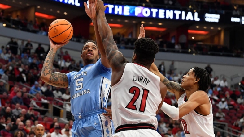North Carolina forward Armando Bacot (5) shoots over Louisville forward Sydney Curry (21) and forward JJ Traynor (12) during the first half of an NCAA college basketball game in Louisville, Ky., Saturday, Jan. 14, 2023.

Armando Bacot Sydney Curry