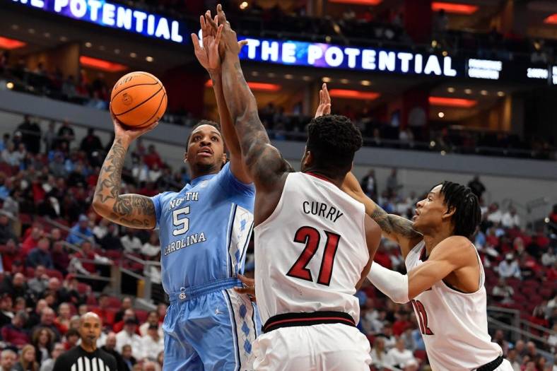 North Carolina forward Armando Bacot (5) shoots over Louisville forward Sydney Curry (21) and forward JJ Traynor (12) during the first half of an NCAA college basketball game in Louisville, Ky., Saturday, Jan. 14, 2023.

Armando Bacot Sydney Curry
