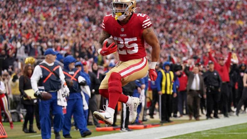 Jan 14, 2023; Santa Clara, California, USA; San Francisco 49ers running back Elijah Mitchell (25) leaps into the end zone for a touchdown in the third quarter of a wild card game against the Seattle Seahawks at Levi's Stadium. Mandatory Credit: Cary Edmondson-USA TODAY Sports