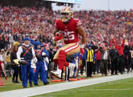 Jan 14, 2023; Santa Clara, California, USA; San Francisco 49ers running back Elijah Mitchell (25) leaps into the end zone for a touchdown in the third quarter of a wild card game against the Seattle Seahawks at Levi's Stadium. Mandatory Credit: Cary Edmondson-USA TODAY Sports