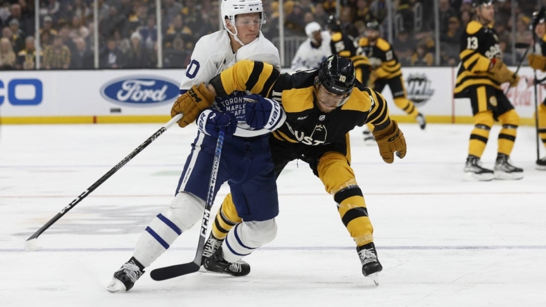 Jan 14, 2023; Boston, Massachusetts, USA; Toronto Maple Leafs left wing Dryden Hunt (20) battles Boston Bruins left wing A.J. Greer (10) for the puck during the first period at TD Garden. Mandatory Credit: Winslow Townson-USA TODAY Sports