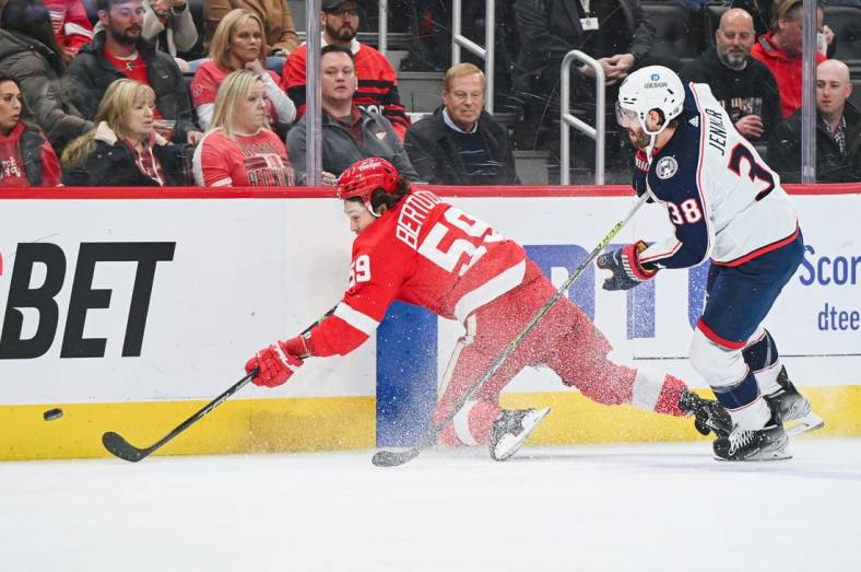 Jan 14, 2023; Detroit, Michigan, USA; Columbus Blue Jackets center Boone Jenner (38) and Detroit Red Wings left wing Tyler Bertuzzi (59) battle for the puck during the first period at Little Caesars Arena. Mandatory Credit: Tim Fuller-USA TODAY Sports