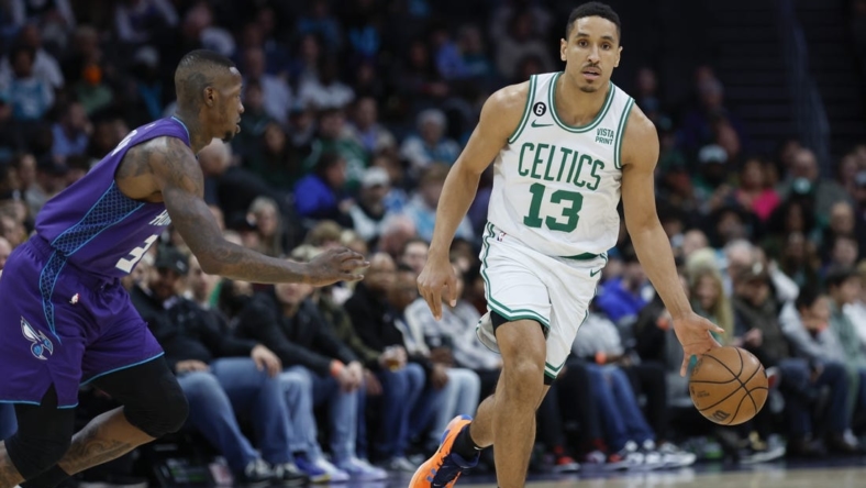 Jan 14, 2023; Charlotte, North Carolina, USA; Boston Celtics guard Malcolm Brogdon (13) controls the ball against Charlotte Hornets guard Terry Rozier (3) during the first half at Spectrum Center. Mandatory Credit: Nell Redmond-USA TODAY Sports