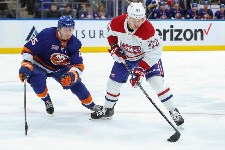 Jan 14, 2023; Elmont, New York, USA;  Montreal Canadiens right wing Evgenii Dadonov (63) moves the puck while New York Islanders defenseman Sebastian Aho (25) pursues during the first period at UBS Arena. Mandatory Credit: Thomas Salus-USA TODAY Sports