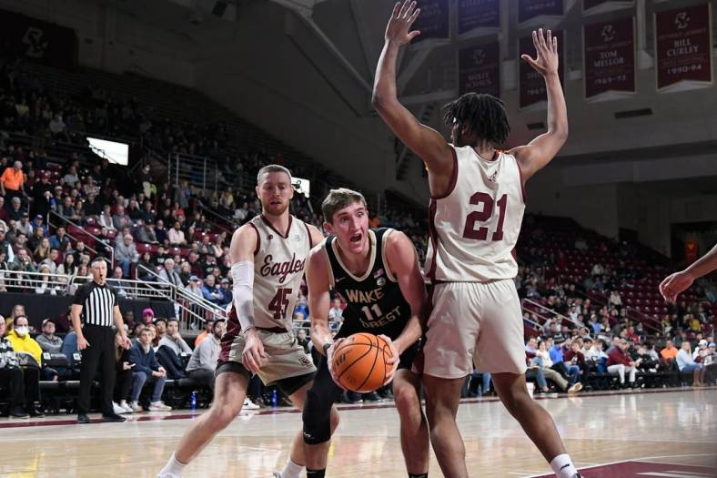 Jan 14, 2023; Chestnut Hill, Massachusetts, USA; Wake Forest Demon Deacons forward Andrew Carr (11) looks for a play around Boston College Eagles forward Devin McGlockton (21)  during the first half at Conte Forum. Mandatory Credit: Eric Canha-USA TODAY Sports