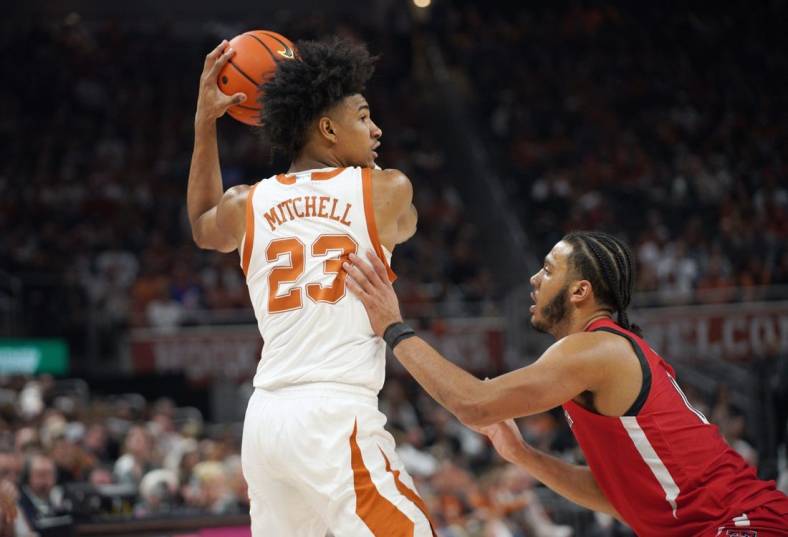 Jan 14, 2023; Austin, Texas, USA; Texas Longhorns forward Dillon Mitchell (23) looks to pass against Texas Tech Red Raiders forward Kevin Obanor (0) during the first half at Moody Center. Mandatory Credit: Dustin Safranek-USA TODAY Sports