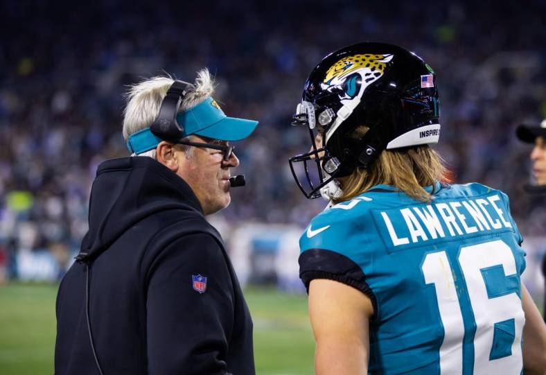 Jan 14, 2023; Jacksonville, Florida, USA; Jacksonville Jaguars quarterback Trevor Lawrence (16) talks with head coach Doug Pederson in the first half against the Los Angeles Chargers during a wild card game at TIAA Bank Field. Mandatory Credit: Mark J. Rebilas-USA TODAY Sports