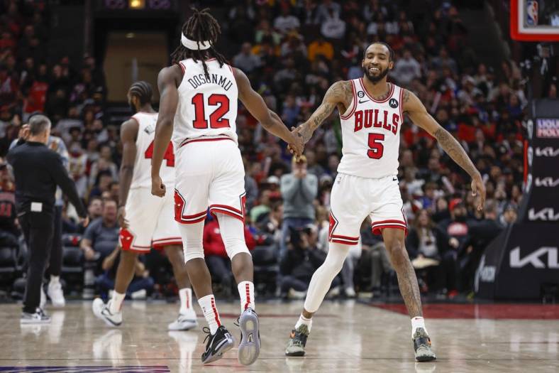 Jan 15, 2023; Chicago, Illinois, USA; Chicago Bulls guard Ayo Dosunmu (12) is congratulated by forward Derrick Jones Jr. (5) after scoring against the Golden State Warriors during the second half of an NBA game at United Center. Mandatory Credit: Kamil Krzaczynski-USA TODAY Sports
