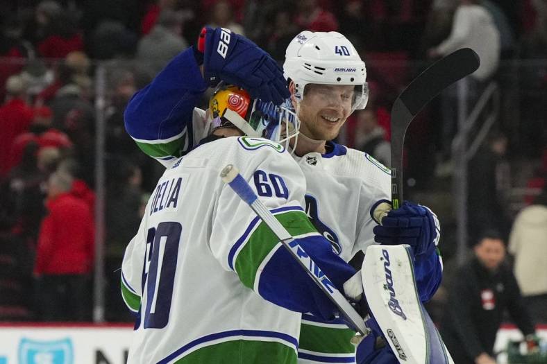 Jan 15, 2023; Raleigh, North Carolina, USA;  Vancouver Canucks goaltender Collin Delia (60) celebrates their victory with center Elias Pettersson (40) in the shootout against the Carolina Hurricanes at PNC Arena. Mandatory Credit: James Guillory-USA TODAY Sports