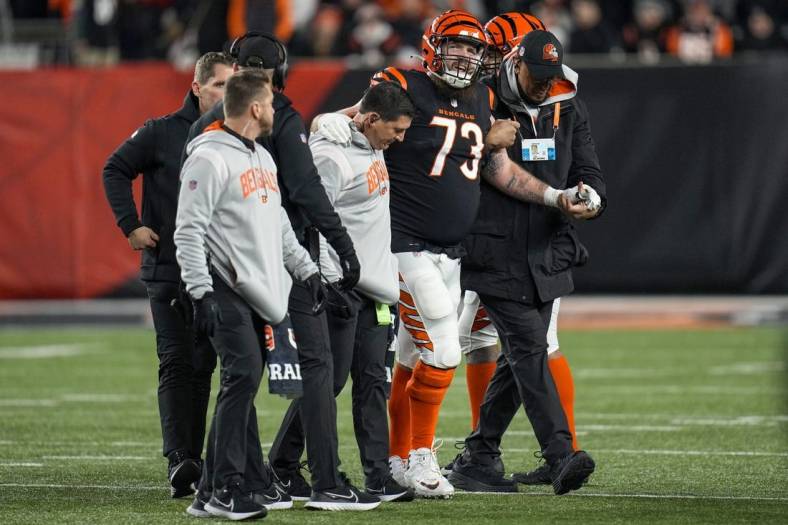 Jan 15, 2023; Cincinnati, Ohio, USA; Cincinnati Bengals offensive tackle Jonah Williams (73) is assisted off the field after being injured on a play in the second quarter during an NFL wild-card playoff football game between the Baltimore Ravens and the Cincinnati Bengals at Paycor Stadium. Mandatory Credit: Sam Greene-USA TODAY Sports